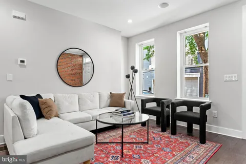 a living room with furniture a rug a lamp and a table
