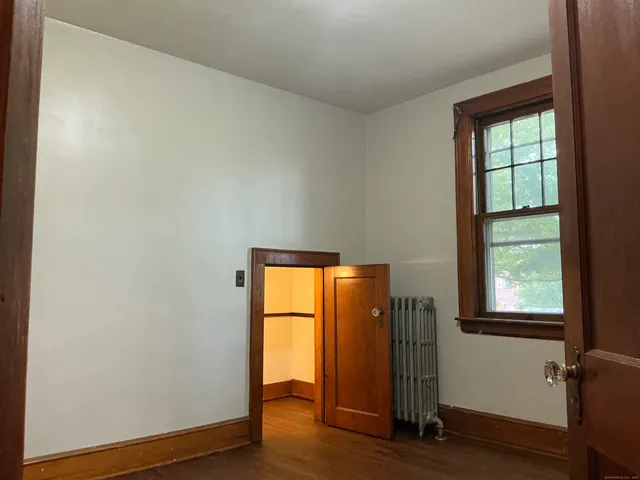 an empty room with wooden floor and a window