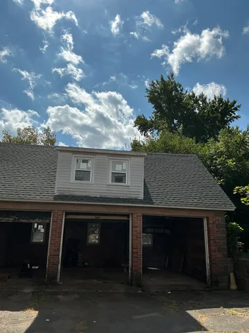 a front view of a house with yard and parking garage