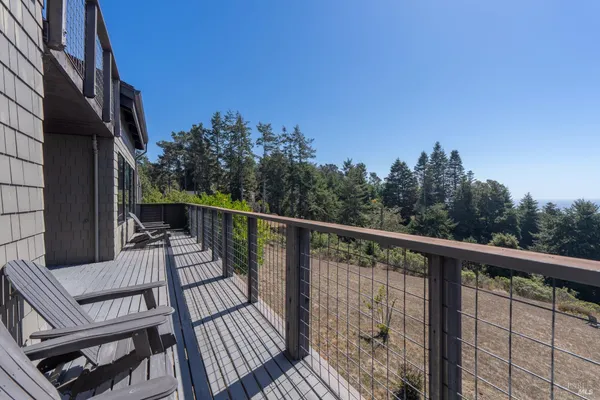 a view of a balcony with wooden floor and outdoor seating