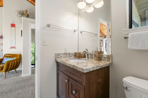 a bathroom with a granite countertop sink a large mirror and a window