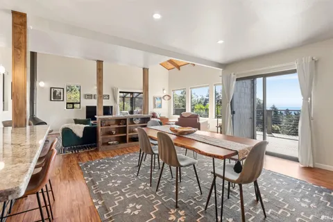 a view of a dining room with furniture large windows and wooden floor