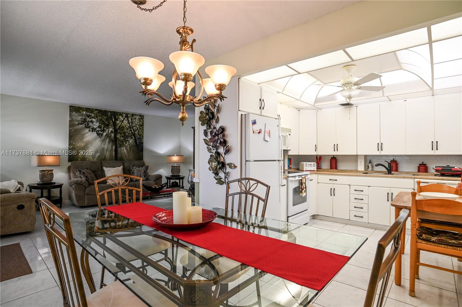 4110 Oakridge V, Unit 4110 Deerfield Beach, FL 33442 - Photo 12 of 63 a view of a dining room with furniture and chandelier