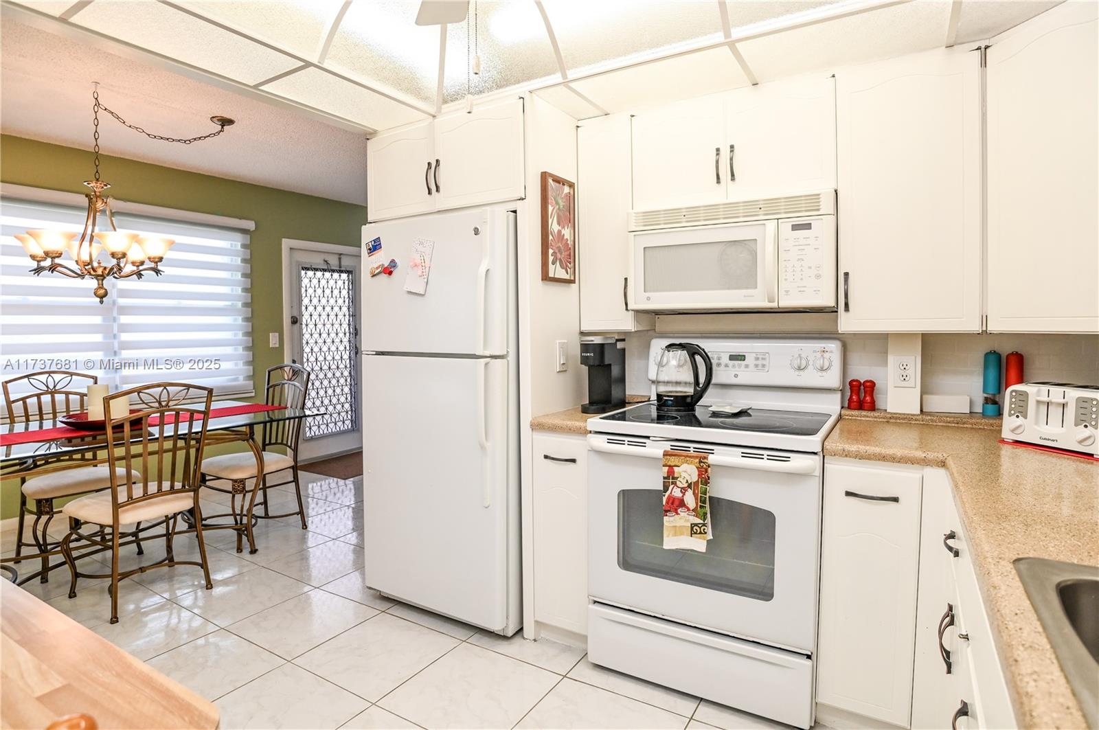 4110 Oakridge V, Unit 4110 Deerfield Beach, FL 33442 - Photo 14 of 63 a kitchen with stainless steel appliances and white cabinets