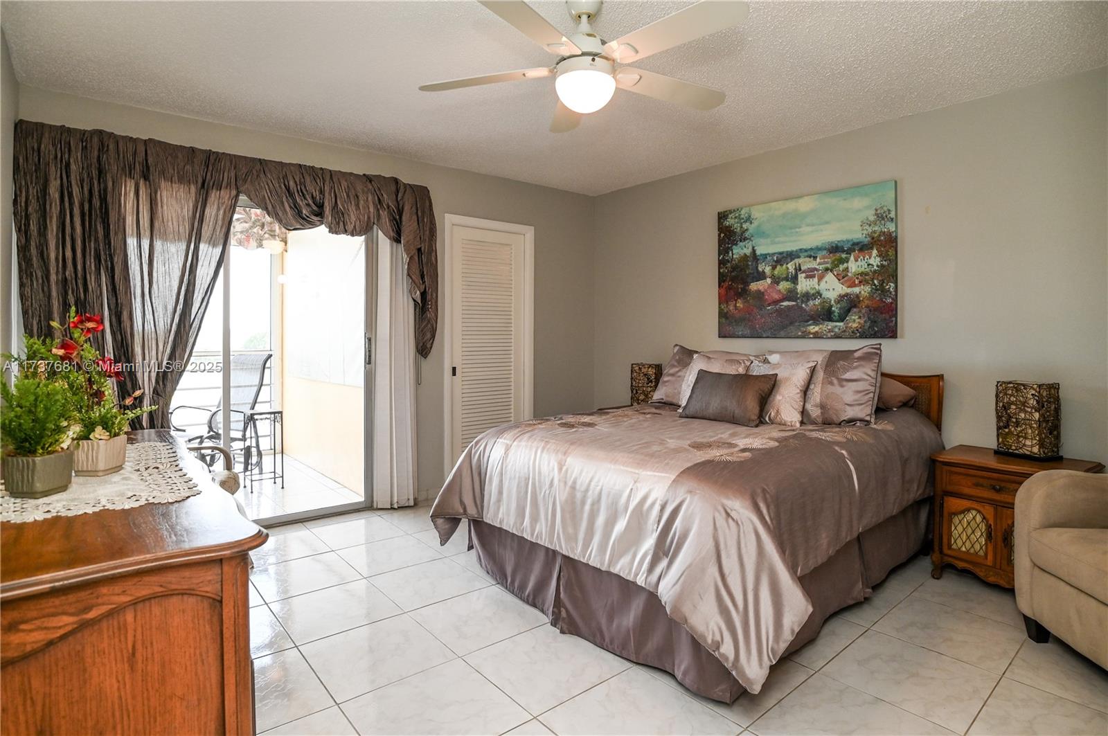 4110 Oakridge V, Unit 4110 Deerfield Beach, FL 33442 - Photo 17 of 63 a bedroom with a large bed and a chandelier