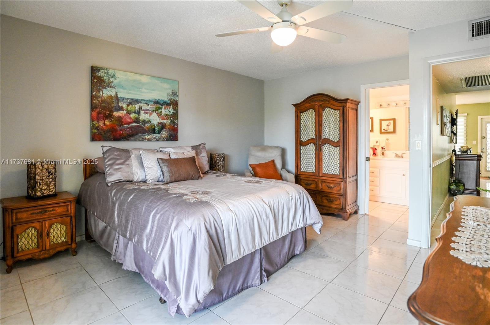 4110 Oakridge V, Unit 4110 Deerfield Beach, FL 33442 - Photo 20 of 63 a bedroom with a bed and a chandelier