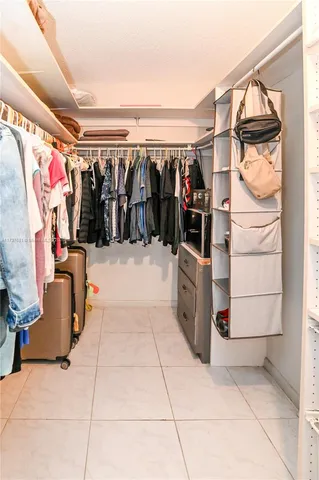 a view of walk in closet with clothes and shoes