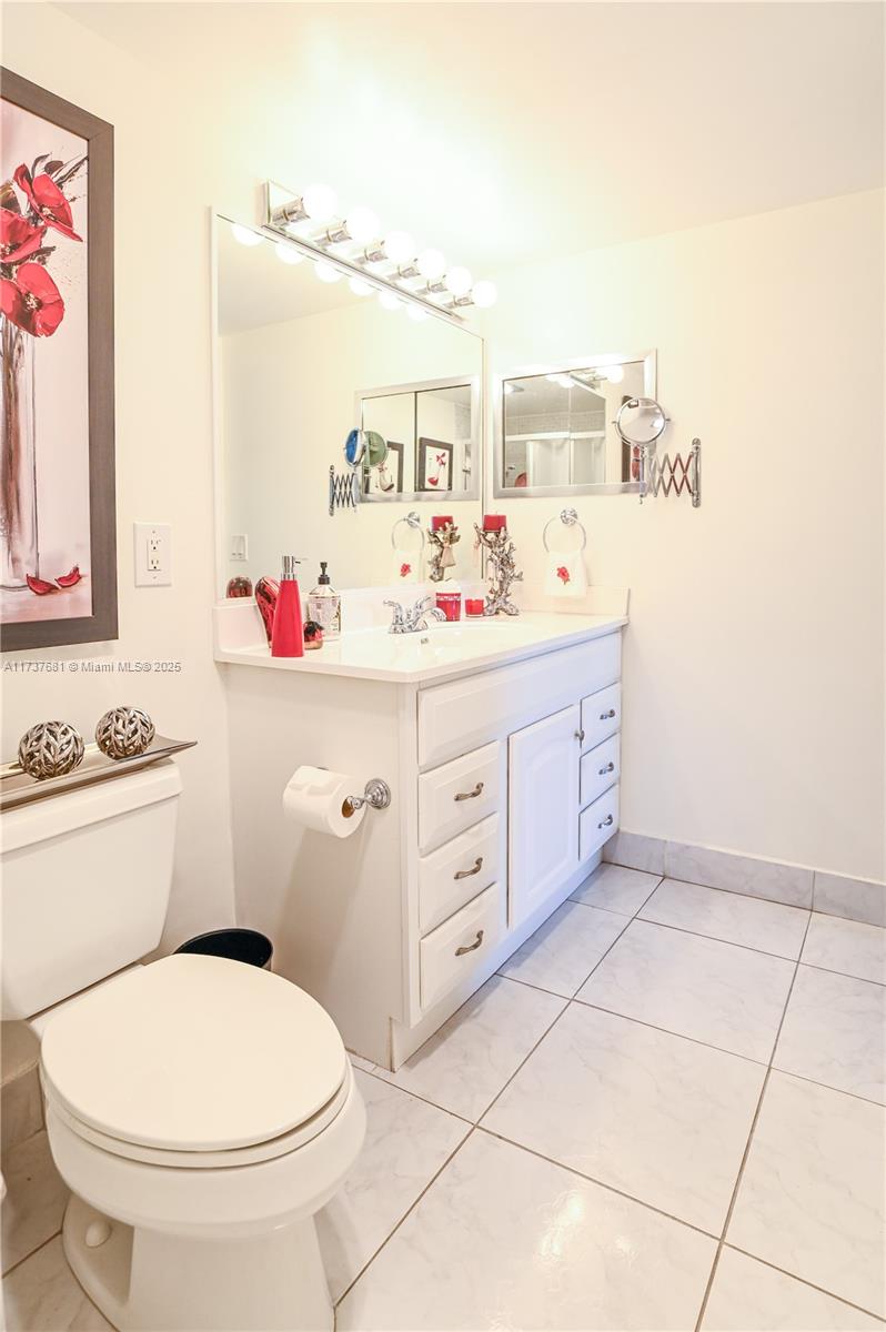 4110 Oakridge V, Unit 4110 Deerfield Beach, FL 33442 - Photo 24 of 63 a bathroom with a sink a toilet and a mirror