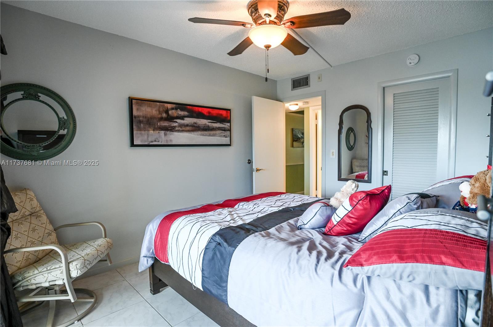 4110 Oakridge V, Unit 4110 Deerfield Beach, FL 33442 - Photo 29 of 63 a bedroom with a bed and a chandelier
