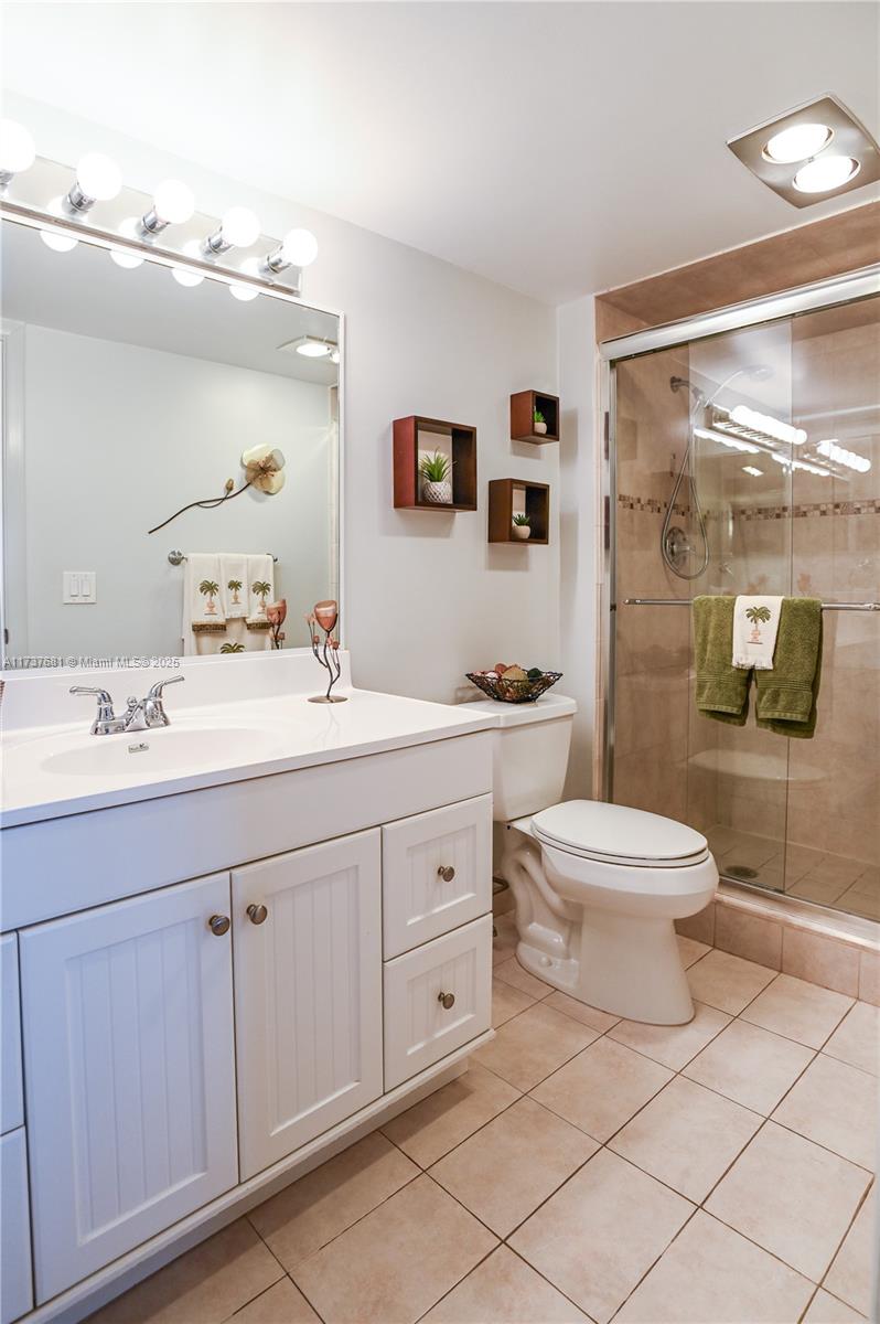 4110 Oakridge V, Unit 4110 Deerfield Beach, FL 33442 - Photo 32 of 63 a bathroom with a double vanity sink mirror and toilet