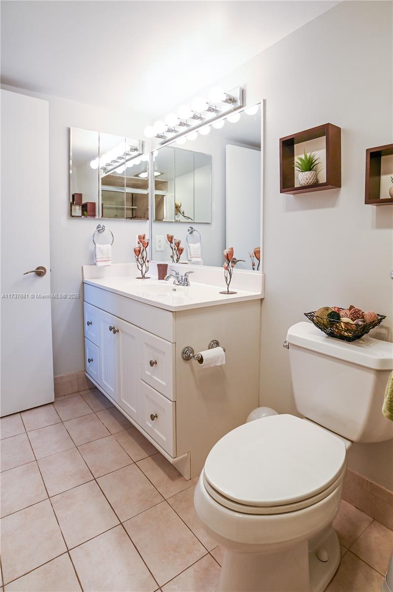 4110 Oakridge V, Unit 4110 Deerfield Beach, FL 33442 - Photo 34 of 63 a bathroom with a toilet a sink and mirror