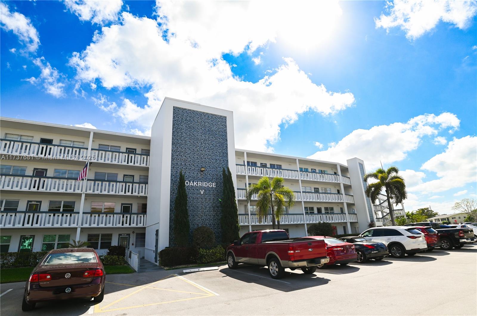 4110 Oakridge V, Unit 4110 Deerfield Beach, FL 33442 - Photo 49 of 63 a view of a cars parked in front of a building
