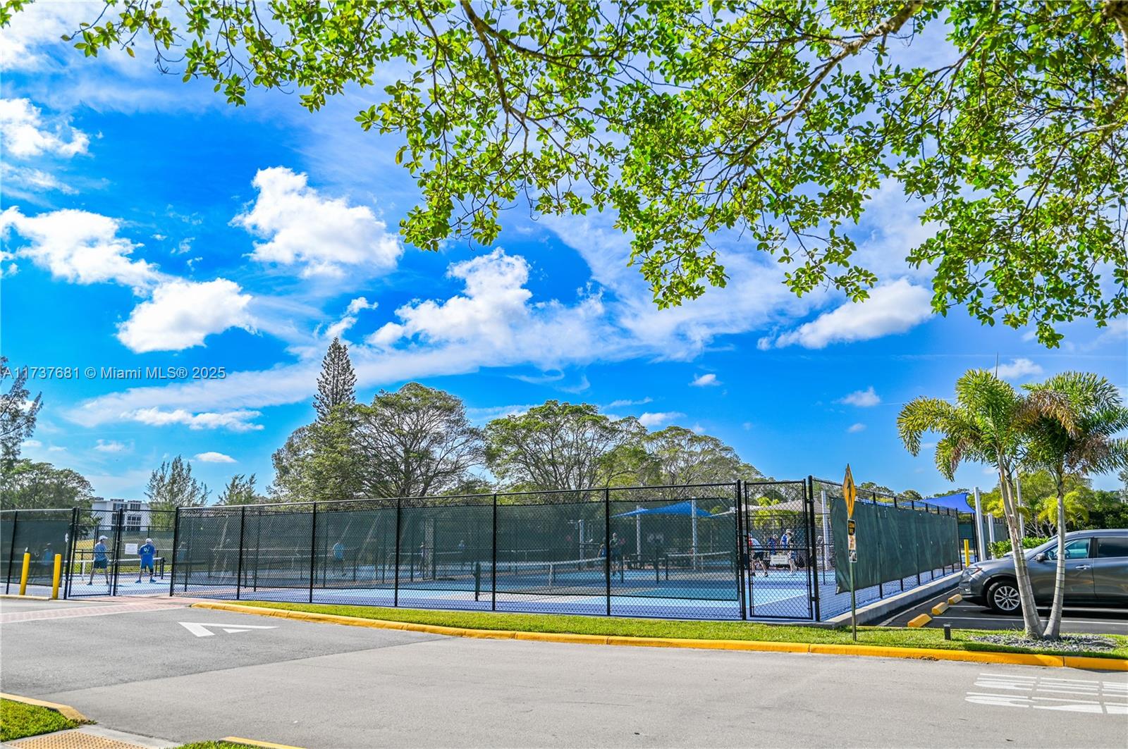 4110 Oakridge V, Unit 4110 Deerfield Beach, FL 33442 - Photo 59 of 63 a view of a swimming pool with an outdoor seating and a yard