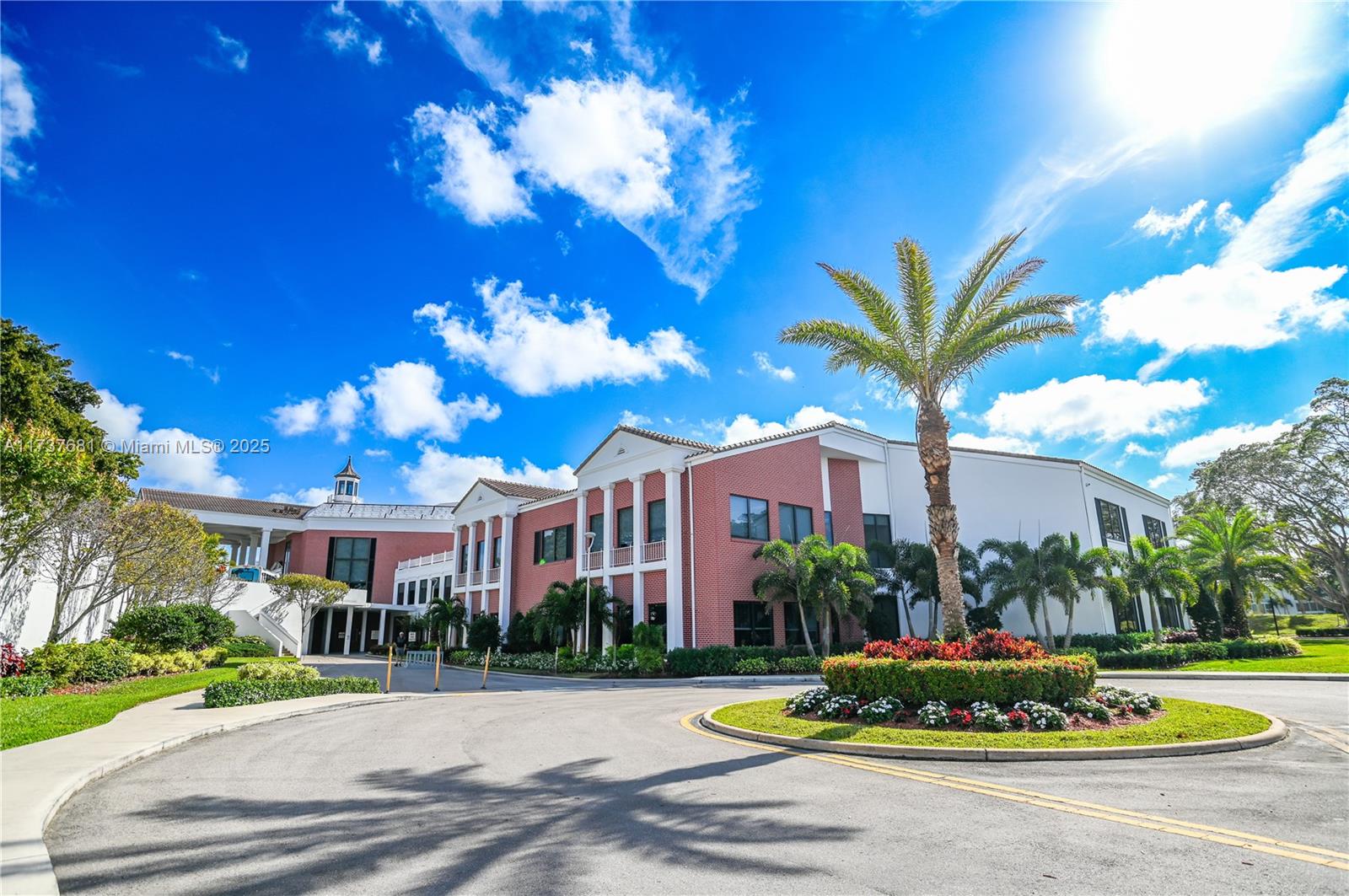 4110 Oakridge V, Unit 4110 Deerfield Beach, FL 33442 - Photo 60 of 63 a front view of a multi story residential apartment building with yard and seating space