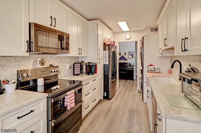 a kitchen with granite countertop a sink stove and refrigerator
