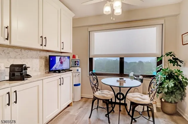 a kitchen with stainless steel appliances a white table chairs and a refrigerator