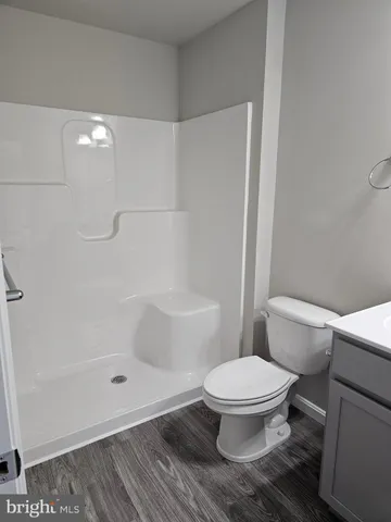 a white toilet sitting next to a bathroom sink and a shower