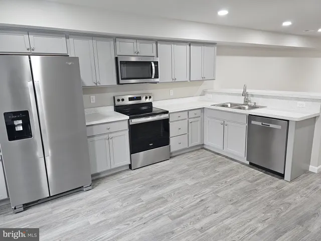 a kitchen with stainless steel appliances granite countertop a refrigerator stove a sink and a microwave