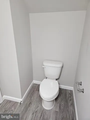 a white toilet sitting next to a wooden cabinet