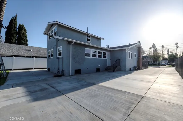 a backyard of a house with wooden floor and large windows