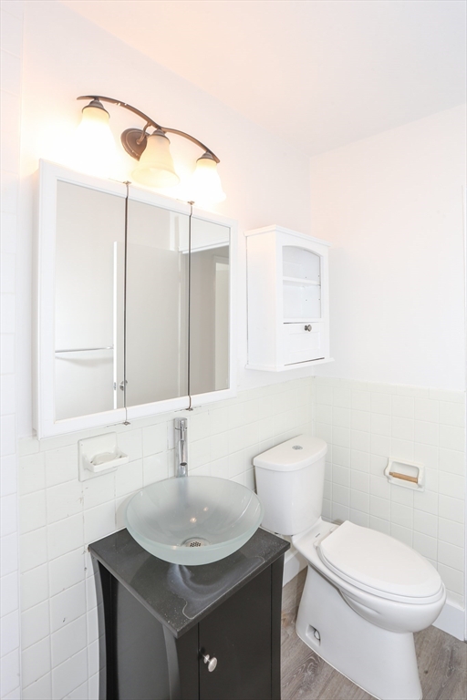 461 Washington Street, Unit 301 Boston, MA 02135 - Photo 12 of 13 a bathroom with a sink toilet and mirror