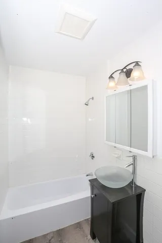a bathroom with a bathtub a sink and a mirror