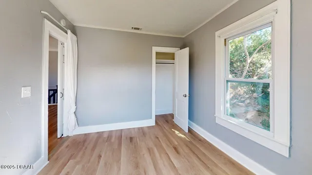 a view of a room with wooden floor and window