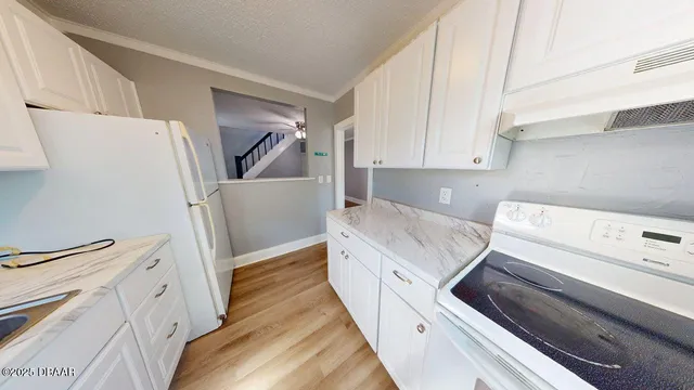 a kitchen with a refrigerator stove and white cabinets
