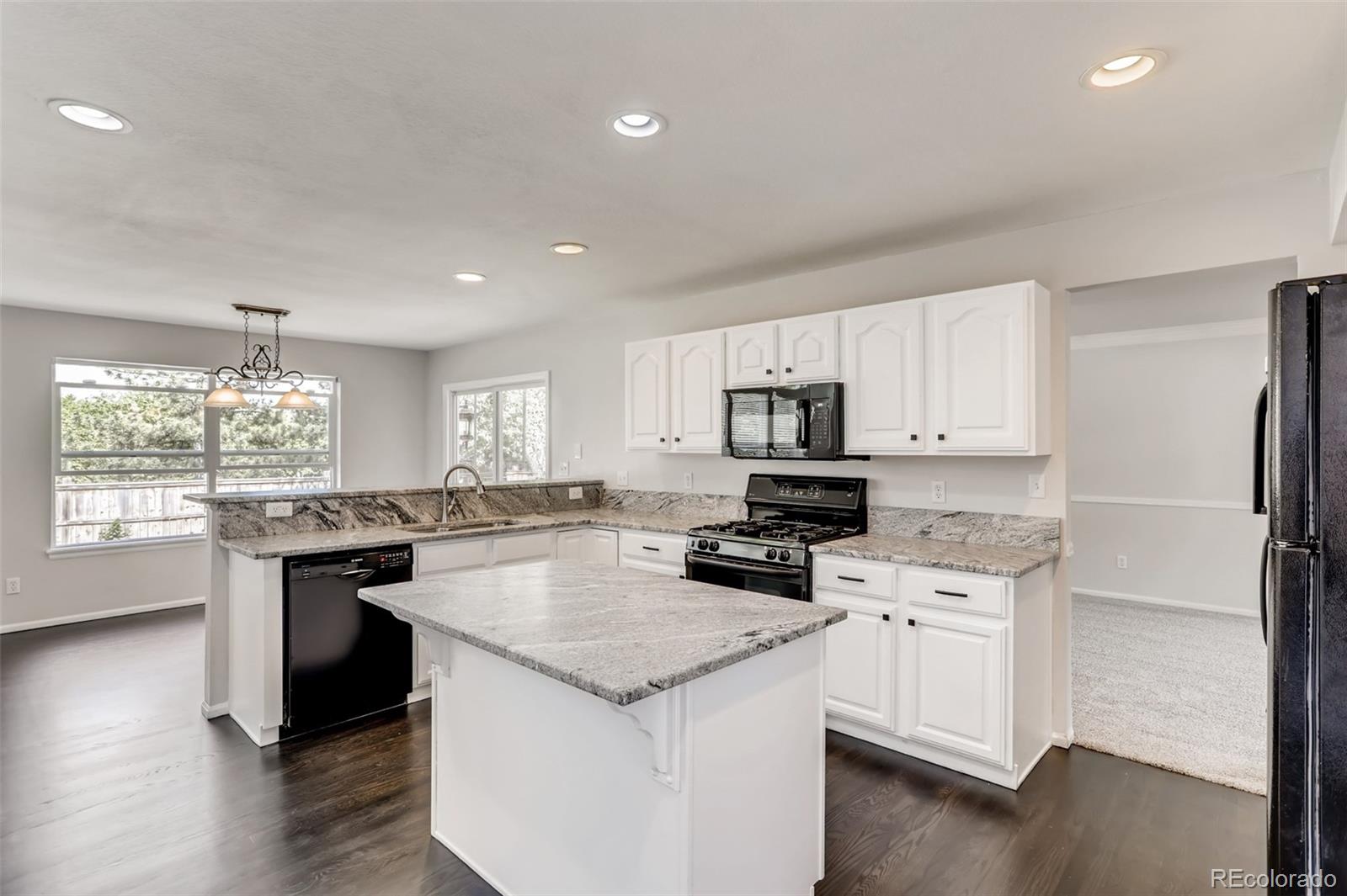 1639 Spring Water Lane Highlands Ranch, CO 80129 - Photo 13 of 39 a kitchen with granite countertop a sink stove and refrigerator