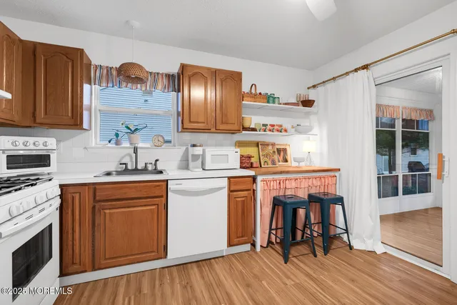 a kitchen with stainless steel appliances a stove a sink dishwasher and cabinets with wooden floor