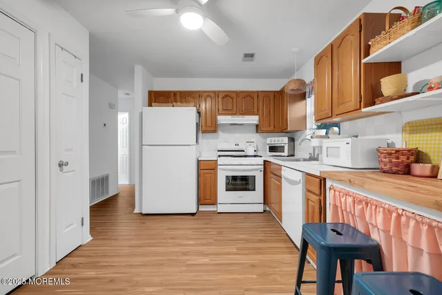 a kitchen with granite countertop a refrigerator a stove a sink and cabinets