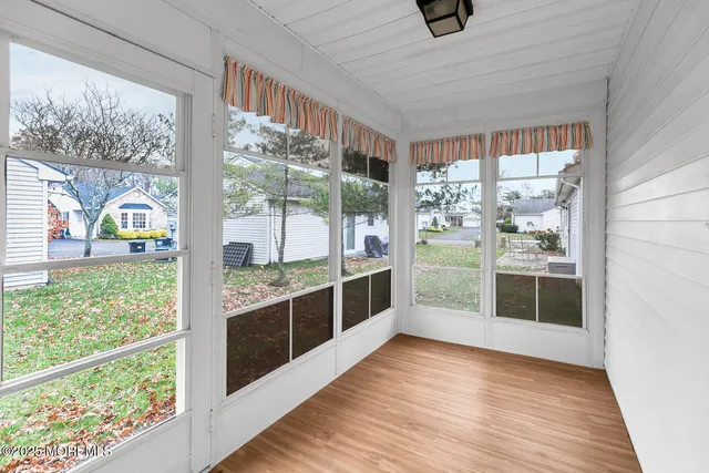 a kitchen with stainless steel appliances wooden floor and a large window