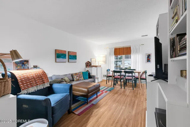 a living room with furniture a dining table and a wooden floor