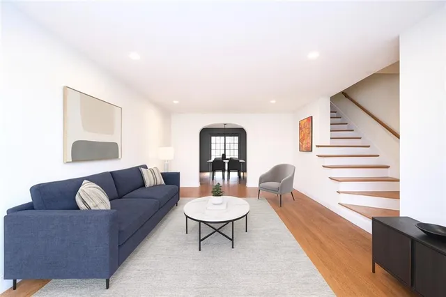 a living room with furniture and a wooden floor