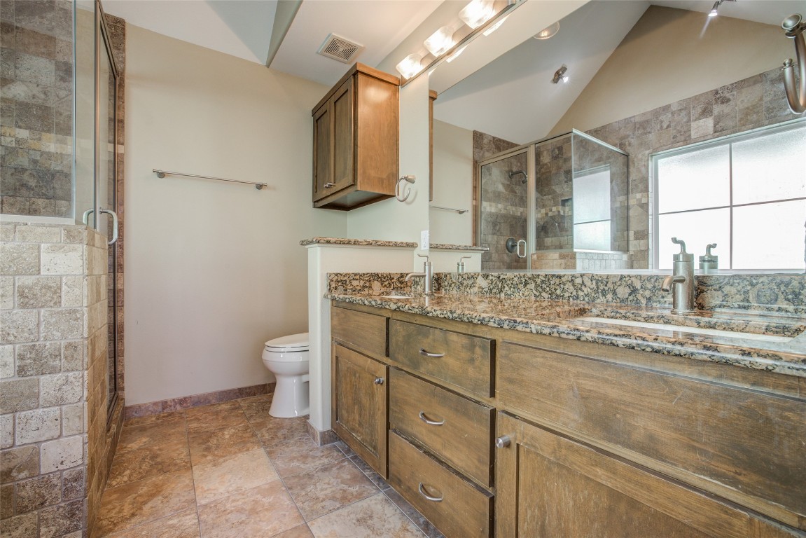 4109 East 12th Street, Unit 2 Austin, TX 78721 - Photo 25 of 39 a bathroom with a granite countertop sink mirror and a toilet