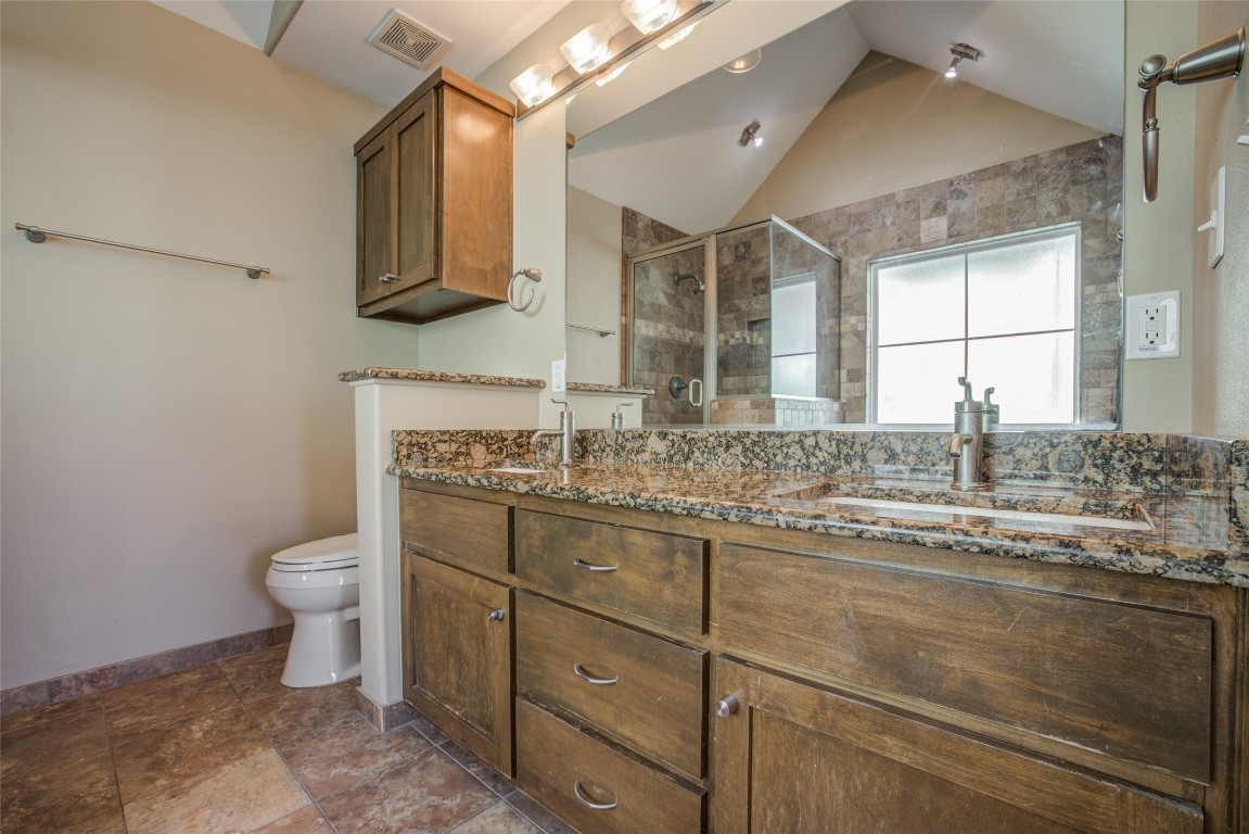 4109 East 12th Street, Unit 2 Austin, TX 78721 - Photo 26 of 39 a bathroom with a granite countertop toilet sink and mirror