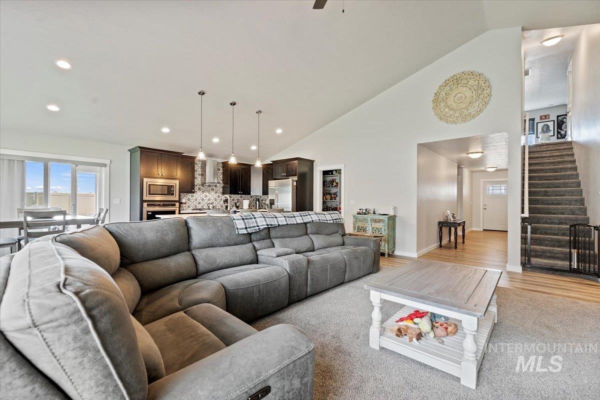 1211 Mahogany Street Parma, ID 83660 - Photo 7 of 30 Living room featuring stairs, recessed lighting, high vaulted ceiling, light wood-style flooring, and a ceiling fan