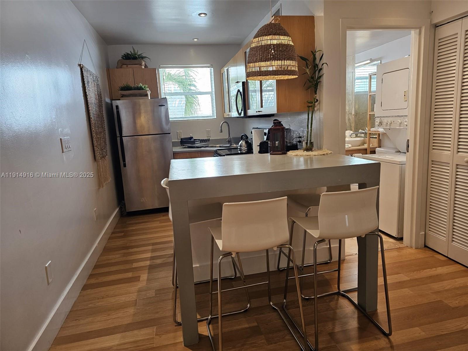 751 Collins Avenue, Unit 2 Miami Beach, FL 33139 - Photo 12 of 25 a kitchen with stainless steel appliances a dining table chairs refrigerator and sink