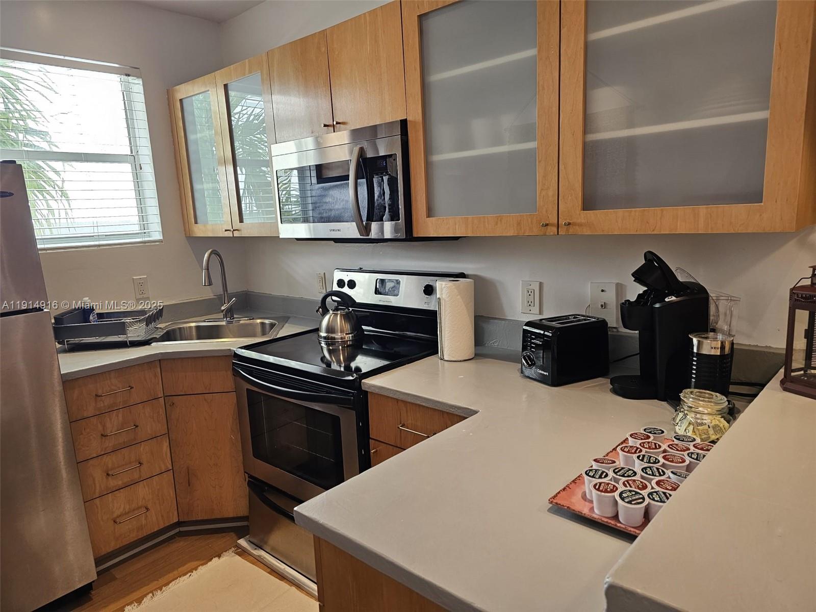751 Collins Avenue, Unit 2 Miami Beach, FL 33139 - Photo 21 of 25 a kitchen with stainless steel appliances granite countertop a sink stove and refrigerator