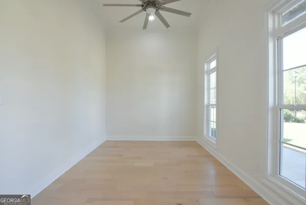 an empty room with a window and a fan