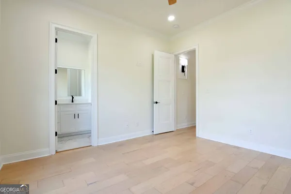 an empty room with mirror and a bathroom