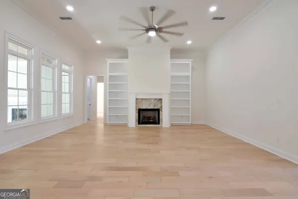 an empty room with windows and fireplace