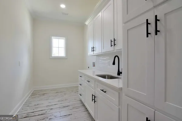 a kitchen with white cabinets and sink