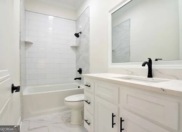 a bathroom with a granite countertop toilet a sink and a bathtub
