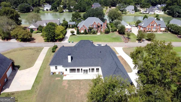 an aerial view of residential houses with outdoor space and lake view