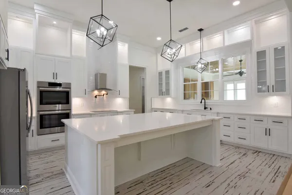 a kitchen with cabinets appliances and a chandelier