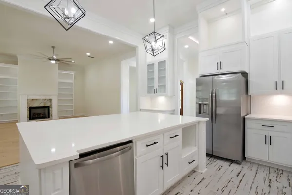 a kitchen with stainless steel appliances a refrigerator sink and fireplace
