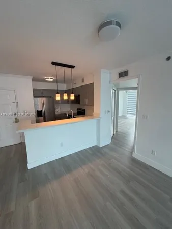 a kitchen with granite countertop white cabinets and wooden floor