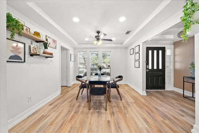 a dining room with wooden floor and stainless steel appliances