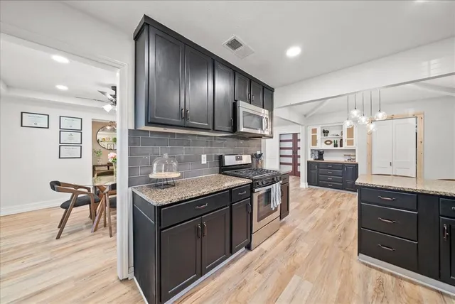a kitchen with granite countertop stainless steel appliances and wooden cabinets